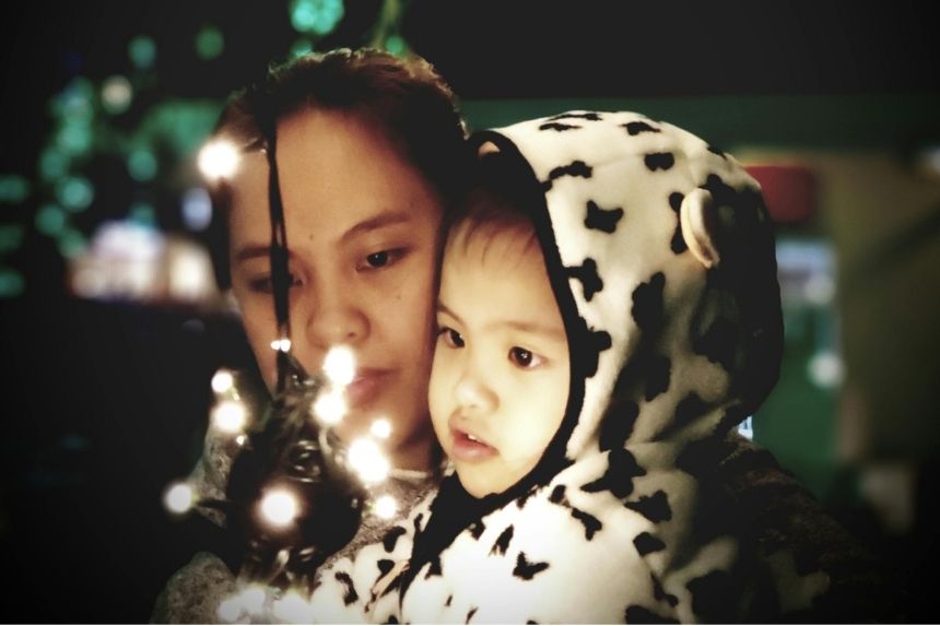 Son and mother admiring an ornament as a means to Making Christmas Memorable for Your Disabled or Neurodivergent Child